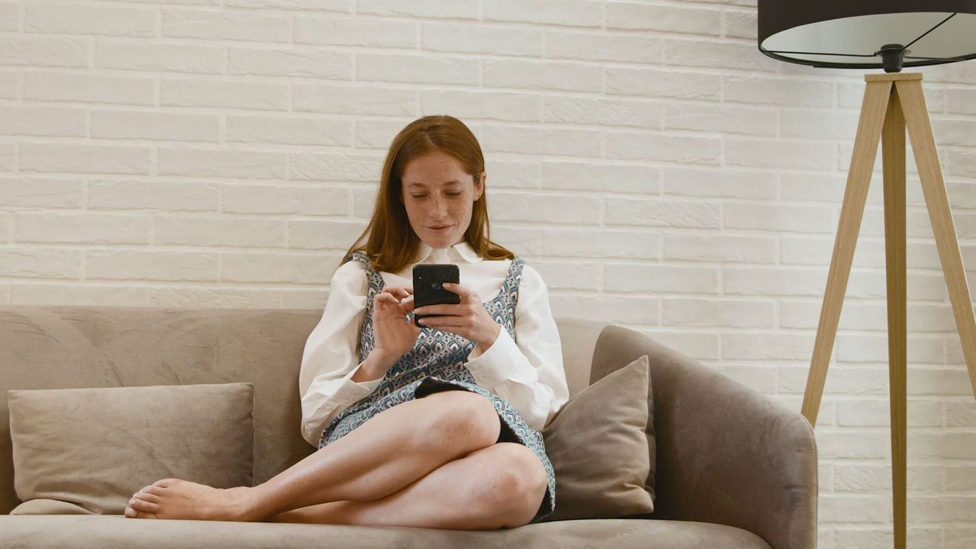 woman sitting on the sofa looking at the virtual mobile shopping