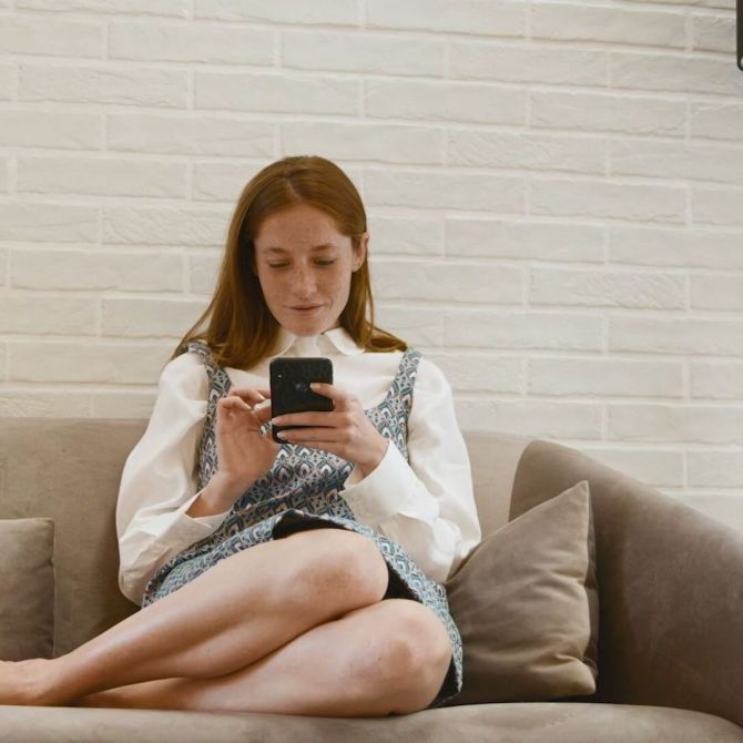 woman sitting on the sofa looking at the virtual mobile shopping