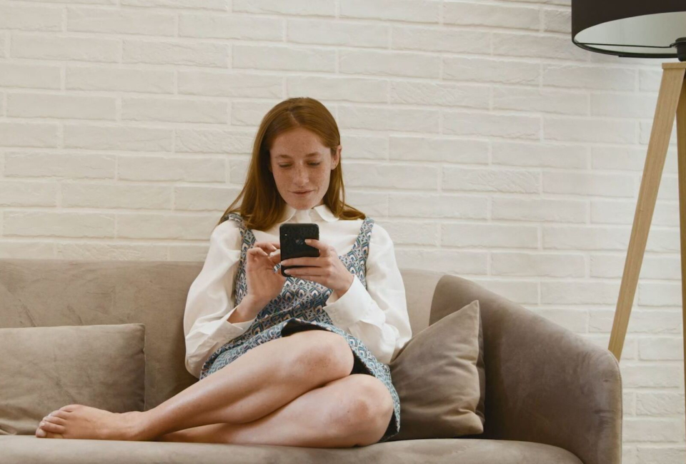 mujer sentada en el sofa mirando el mobil  virtual shopping