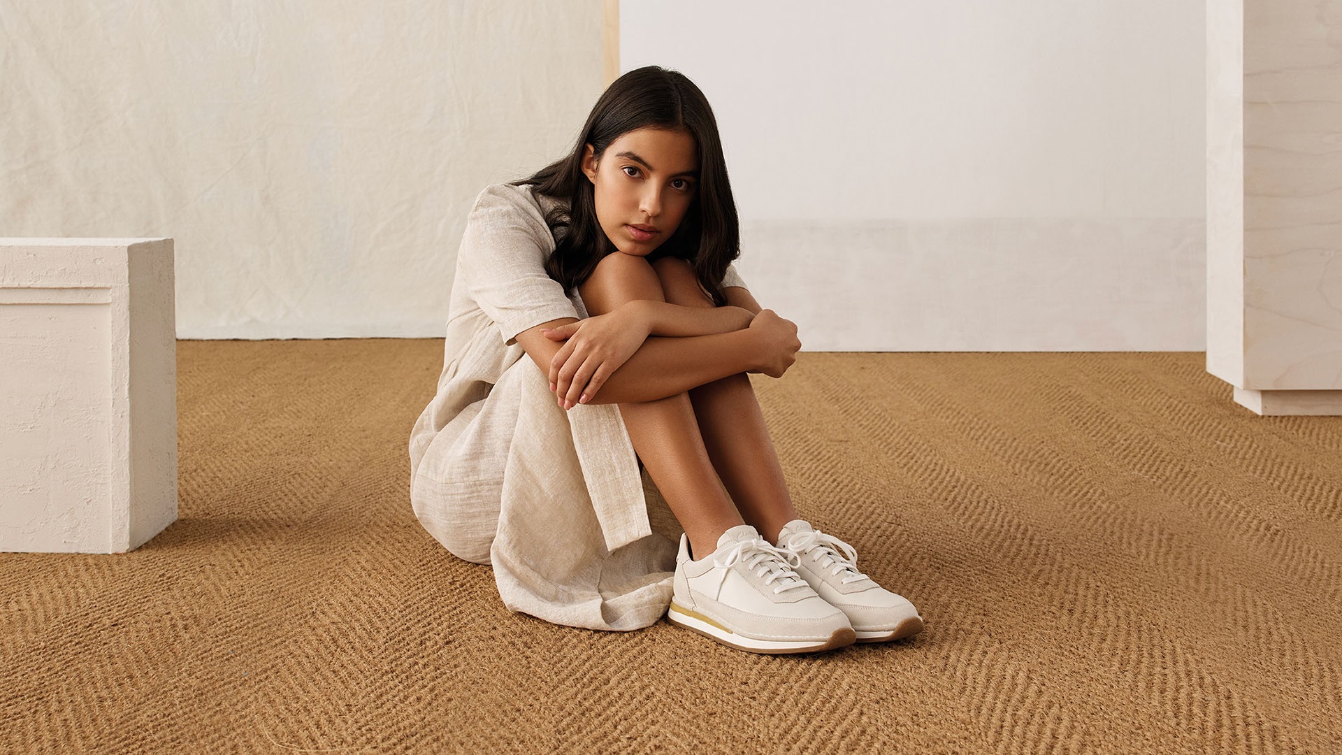 Girl on the floor with a clarks sneakers