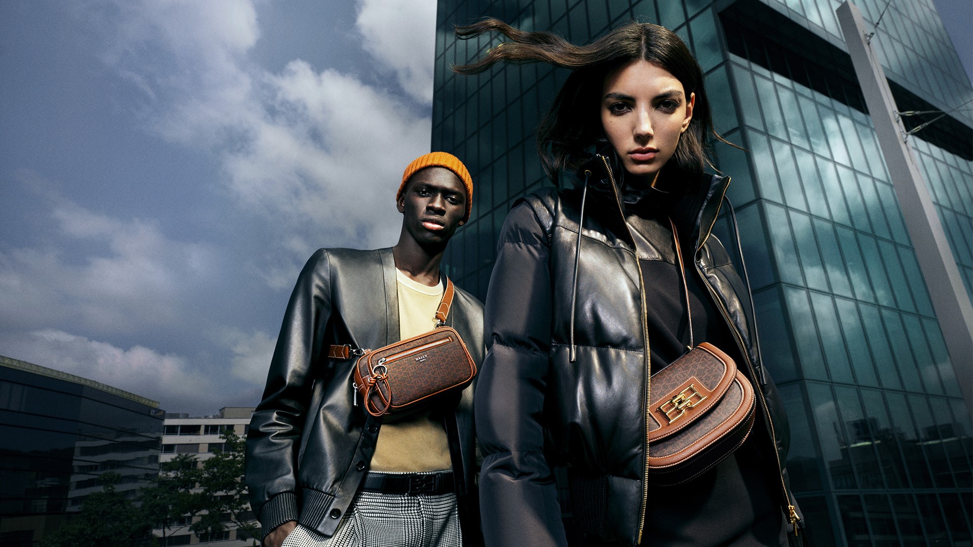 Man and woman in the countryside with Bally jackets and bags